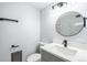 Bright bathroom featuring a modern vanity, round mirror and sleek black fixtures at 2203 S Holly St # 3, Denver, CO 80222