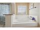 Oversized soaking tub with stylish tile surround and window providing natural light at 28700 E 160Th Pl, Brighton, CO 80603