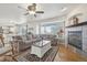 Bright living room featuring hardwood floors, a fireplace, large windows, and comfortable seating at 28700 E 160Th Pl, Brighton, CO 80603