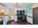 Bright kitchen equipped with stainless steel appliances, white cabinets, and dark hardwood flooring at 2080 S King St, Denver, CO 80219