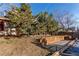 Spacious backyard featuring retaining wall with garden bed and mature landscaping at 1149 S Kittredge St, Aurora, CO 80017