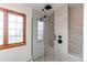 Modern bathroom featuring tiled shower with glass door and wood framed window at 1149 S Kittredge St, Aurora, CO 80017