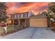 Charming two-story home with brick facade, covered porch, manicured lawn, and a two-car garage at sunset at 1149 S Kittredge St, Aurora, CO 80017