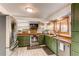 Well-lit kitchen features stainless steel appliances, wood counters, green cabinets and brick backsplash at 1149 S Kittredge St, Aurora, CO 80017