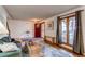 Inviting living room featuring hardwood floors, a sofa, large windows with curtains and a red front door at 1149 S Kittredge St, Aurora, CO 80017