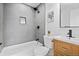 Updated bathroom featuring tile walls, shower over tub, and stylish vanity at 3460 S Eudora St, Denver, CO 80222