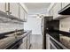 Galley kitchen with stainless steel appliances and gray cabinets at 309 E Highline Cir # 103, Centennial, CO 80122