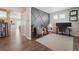 Home office features wood floors, gray accent wall, and view into adjacent living space at 1123 Sunrise Dr, Brighton, CO 80603