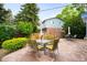 Relaxing backyard patio featuring stone pavers, patio set, and lush greenery, perfect for outdoor enjoyment at 9765 W 77Th Dr, Arvada, CO 80005
