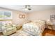 Bright bedroom featuring a ceiling fan, a window with shutters, chair and hardwood flooring at 9765 W 77Th Dr, Arvada, CO 80005