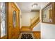 Inviting foyer showcasing a grand staircase, hardwood floors, and a decorative front door at 9765 W 77Th Dr, Arvada, CO 80005