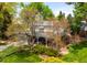 Attractive home showcasing a lush front yard, mature trees, and inviting entryway with blue garage doors at 9765 W 77Th Dr, Arvada, CO 80005