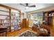 Cozy home office with custom built-in bookshelves, a ceiling fan, and hardwood flooring at 9765 W 77Th Dr, Arvada, CO 80005
