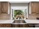 Close up of modern kitchen sink with a view to the exterior yard and natural light at 9765 W 77Th Dr, Arvada, CO 80005
