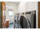 Convenient laundry room with modern washer and dryer, plus storage cabinets above at 9765 W 77Th Dr, Arvada, CO 80005