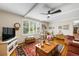 Cozy living room with hardwood floors, ceiling fan, and large window with natural light at 9765 W 77Th Dr, Arvada, CO 80005