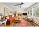 Comfortable living room featuring a brick fireplace, hardwood floors, and large windows at 9765 W 77Th Dr, Arvada, CO 80005