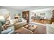 Spacious living room open to dining area, featuring hardwood floors and natural light at 9765 W 77Th Dr, Arvada, CO 80005