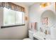 Cozy powder room featuring a vanity with sink and a window providing natural light at 9765 W 77Th Dr, Arvada, CO 80005