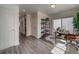 Hallway with hardwood floors leading to an office with modern shelving and sliding glass door at 10379 Vaughn Way, Commerce City, CO 80022