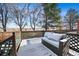 Backyard wooden deck seating area with lattice railing, snow on ground, and lake view at 10092 Lee St, Broomfield, CO 80021