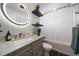 Modern bathroom with a lighted round mirror, floating shelves and a combination tub and shower at 10092 Lee St, Broomfield, CO 80021