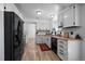 Bright kitchen featuring white cabinets, butcher block countertops, black appliances, and wood-look flooring at 10092 Lee St, Broomfield, CO 80021