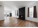 Open living room featuring a painted brick fireplace, hardwood floors, and access to a private balcony at 10092 Lee St, Broomfield, CO 80021