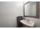 Cozy powder room featuring a pedestal sink, decorative mirror, and fresh white paint at 10092 Lee St, Broomfield, CO 80021