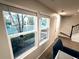 Living room featuring large windows providing plenty of natural light, with stairs visible in the background at 10676 Forester Pl, Longmont, CO 80504