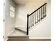Carpeted staircase with black railing and natural light from a nearby window at 10676 Forester Pl, Longmont, CO 80504