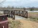 Picturesque walking bridge with view of lake and natural vegetation at 10676 Forester Pl, Longmont, CO 80504