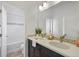 Modern bathroom with double sinks, quartz countertops, decorative tile backsplash, and tub with tiled shower at 198 Starlight Cir, Erie, CO 80516