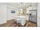 Updated kitchen with white cabinets, island seating, stainless appliances, and modern pendant lighting at 198 Starlight Cir, Erie, CO 80516