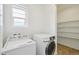 Bright laundry room featuring washer, dryer, and ample shelving for storage at 198 Starlight Cir, Erie, CO 80516