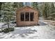 Charming cabin exterior showcasing a simple design, surrounded by winter snow and trees at 846 Circle K Ranch Rd, Evergreen, CO 80439