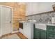 Well-lit laundry room with wood accents, farm sink, modern tiling, and full washer and dryer at 846 Circle K Ranch Rd, Evergreen, CO 80439
