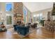 Open concept living area features stone fireplace, hardwood flooring, and large windows with natural light at 846 Circle K Ranch Rd, Evergreen, CO 80439
