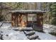 Exterior shot of rustic cabin with snow, wood siding, window and door at 846 Circle K Ranch Rd, Evergreen, CO 80439
