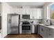 Modern kitchen features stainless steel appliances, white cabinets, and wood floor at 1305 Osceola St, Denver, CO 80204