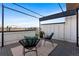 Relaxing rooftop patio area with stylish seating, patterned cushions, and sleek black metal framing with great views at 1305 Osceola St, Denver, CO 80204