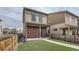 Home's backyard with artificial grass, patio and walkway along a tall wooden fence at 12770 Tamarac St, Thornton, CO 80602