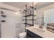 Bright bathroom featuring a shower and storage shelves for towels and other items at 12770 Tamarac St, Thornton, CO 80602