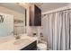 Bathroom with a shower featuring a gray shower curtain, and a dark cabinet at 12770 Tamarac St, Thornton, CO 80602
