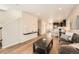 Bright living room featuring wood flooring, modern decor, and open access to the kitchen and dining area at 12770 Tamarac St, Thornton, CO 80602