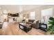 Open concept living room with wood floors, large couch, and a view of the kitchen at 12770 Tamarac St, Thornton, CO 80602