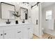 Stylish bathroom featuring dual sinks, sleek fixtures, a modern barn door, and ample counter space at 8497 Madison Way, Denver, CO 80229
