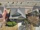 Aerial view of the house featuring a well-manicured lawn, mature trees, solar panels, and a two-car garage at 11060 River Oaks Ln, Commerce City, CO 80640