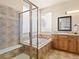 Bathroom featuring soaking tub, tiled shower with glass door, and window at 11060 River Oaks Ln, Commerce City, CO 80640