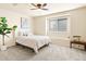 Comfortable bedroom featuring neutral carpet, a ceiling fan, a large window, and stylish decor at 11060 River Oaks Ln, Commerce City, CO 80640